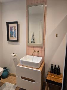a bathroom with a white sink and a mirror at Casa Rosa Cheltenham - luxury unit, free parking - 5 star in Cheltenham