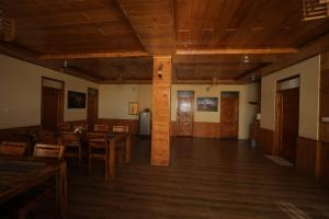 an empty room with wooden floors and tables and chairs at Village Crown in Mundaghat 