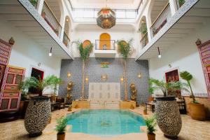 a large indoor pool with plants in a lobby at Riad Dar Mima Hnina - 2 Pools, Breakfast, 10' From Jamaa el-Fna, 10' From Airport in Marrakesh