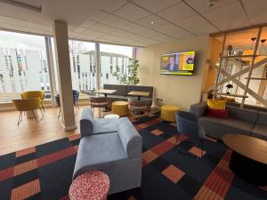 a lobby with a couch and chairs and a table at Holiday Inn Express Nuneaton by IHG in Nuneaton