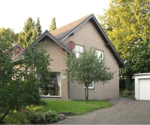 a brick house with a tree in the yard at Ferienwohnung Anna in Wermelskirchen