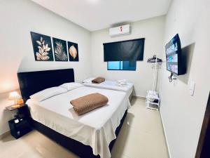 a bedroom with a bed and a flat screen tv at Residencial Mª Do Bonfim - 5km Aeroporto JK in Brasília