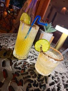 two cocktails sitting on a table with lime slices at BUENAVISTA INN in Maiquetía