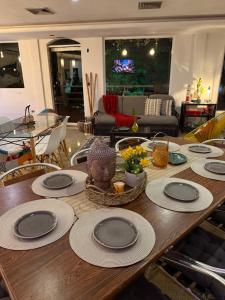 a table with plates and a vase on top of it at BUENAVISTA INN in Maiquetía +40 photos