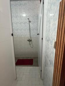 a bathroom with a shower with a red rug at Dar Laila Surf in Tamraght Ouzdar +31 photos