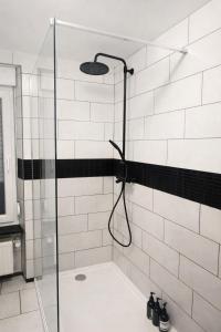a bathroom with a shower with black and white tiles at La maison des Oiseaux in Martelange
