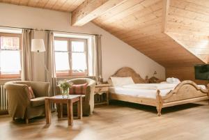 a bedroom with a bed and a chair and a table at Landhaus Alger in Immenstadt im Allgäu