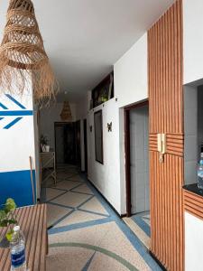 a room with a hallway with a door and a table at Dar Laila Surf in Tamraght Ouzdar
