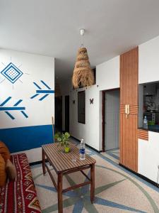 a living room with a table and a kitchen at Dar Laila Surf in Tamraght Ouzdar