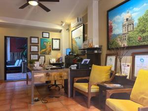 an office with a desk and chairs and a tv at Posada del Cortes in Loreto
