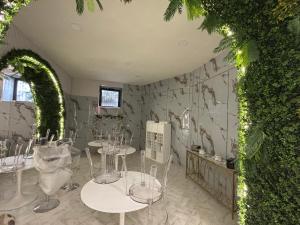 a room with tables and a wall with plants at Guest House Partenope in Naples