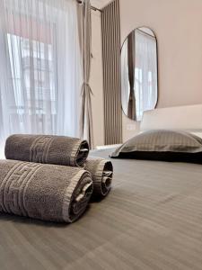 a pile of towels sitting on top of a bed at FLH - Obralix Home in Sibiu