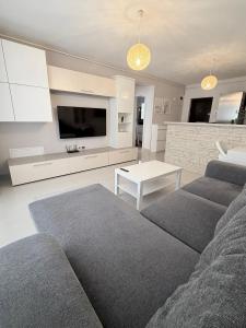 a living room with a couch and a table and a tv at FLH - Obralix Home in Sibiu