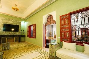 a living room with a couch and a fireplace at Riad Dar Mima Hnina - 2 Pools, Breakfast, 10' From Jamaa el-Fna, 10' From Airport in Marrakesh