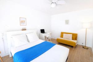 a bedroom with a bed and a yellow chair at Le Kuku Beach - Appartement de charme à Digoin in Digoin