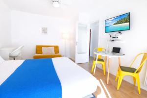 a bedroom with a bed and a table and chairs at Le Kuku Beach - Appartement de charme à Digoin in Digoin