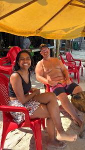 a man and a woman sitting in chairs on the beach at Tipiland baru la casa del mono in Playa Blanca +69 photos
