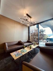 a living room with two couches and a table at Intergroup Business & Design Hotel Ingolstadt in Kösching