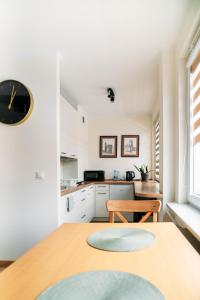 a kitchen with a table and a clock on the wall at Apartament Sandomierski in Sandomierz