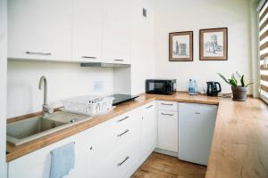 a kitchen with white cabinets and a sink at Apartament Sandomierski in Sandomierz +9 photos