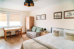 a bedroom with a bed and a chair and a desk at Apartament Sandomierski in Sandomierz