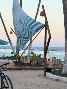 a flag on a beach with the ocean in the background at Pousada Casa de Praia in Marechal Deodoro