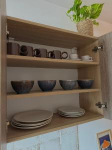 a shelf with bowls and plates in a kitchen at Cozy Apartment - Netflix & Free parking in Žilina +6 photos