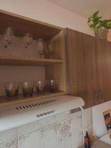 a kitchen with wooden cabinets with wine glasses at Cozy Apartment - Netflix & Free parking in Žilina
