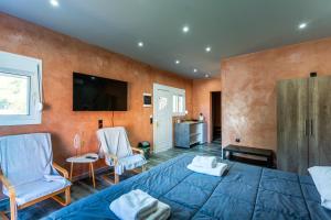 a bedroom with a bed and two chairs and a television at Anna Studios in Marathias