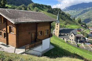 a small building on a hill with a church at Swiss Chalet - upstairs apartment in Grengiols