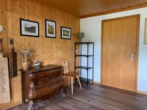 a room with a dresser and a wooden wall at Swiss Chalet - upstairs apartment in Grengiols