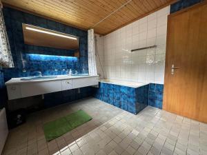 a bathroom with a tub and a sink and a mirror at Swiss Chalet - upstairs apartment in Grengiols