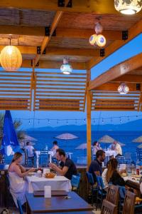 a group of people sitting at tables in a restaurant at Ekin Assos in Ayvacık