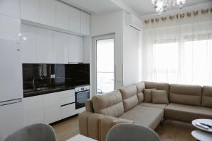 a living room with a couch and a kitchen at Shehu Apartments in Tirana