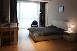 a bedroom with a bed and a chair and a window at Hotel Bobline 304 in Bakuriani