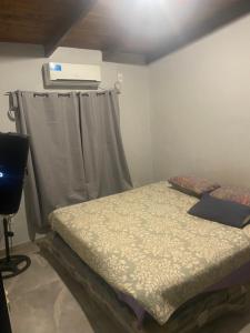 a small bedroom with a bed and a curtain at Casa roja in Eldorado