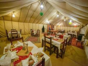 a dining room with tables and chairs in a tent at Dream Land Camp in Merzouga