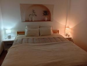 a bedroom with a large bed with two lamps at Casa próxima da praia fluvial in Mourão