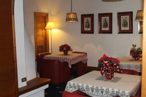 a dining room with two tables with red chairs at Hotel Majoni in Cortina dʼAmpezzo
