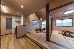 a living room with a table and a kitchen at Hakone Mori No Sato 箱根森の郷 in Sekishoato