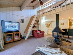a living room with a television and a staircase at Snow Summit Townhouse Unit 09 in Big Bear Lake