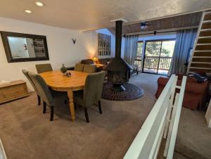 a living room with a wooden table and a fireplace at Snow Summit Townhouse Unit 09 in Big Bear Lake
