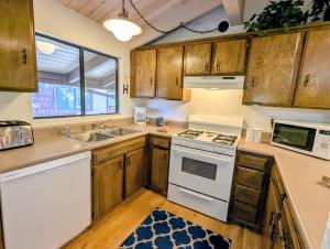 a kitchen with wooden cabinets and a white stove top oven at Snow Summit Townhouse Unit 09 in Big Bear Lake