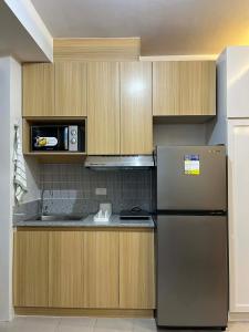 a kitchen with a refrigerator and a microwave at Suite Talie Cebu Cozy Modern Stay with Pool & Netflix in Lapu Lapu City