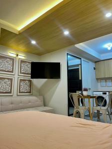 a bedroom with a bed and a couch and a table at Suite Talie Cebu Cozy Modern Stay with Pool & Netflix in Lapu Lapu City