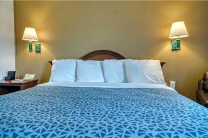 a bed in a hotel room with a blue bedspread at Zanesville Inn in Zanesville