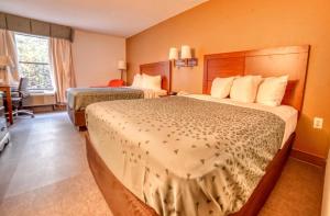 a hotel room with two beds and a window at Zanesville Inn in Zanesville +3 photos