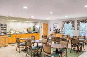 a restaurant with tables and chairs and a kitchen at Zanesville Inn in Zanesville