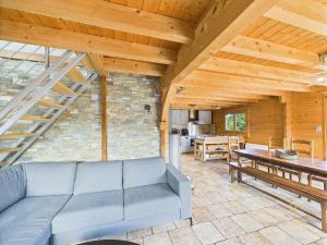 a living room with a blue couch and a table at Cozy chalet with Nordic bath in Plancher-Bas
