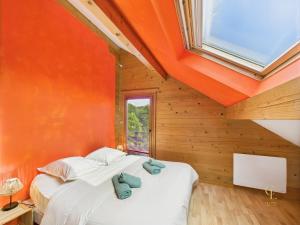 two beds in a room with an orange wall at Cozy chalet with Nordic bath in Plancher-Bas